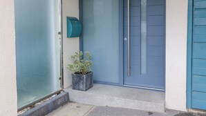 A blue door with a mailbox and a potted plant on the steps. - 6 Inveravon (Christchurch)