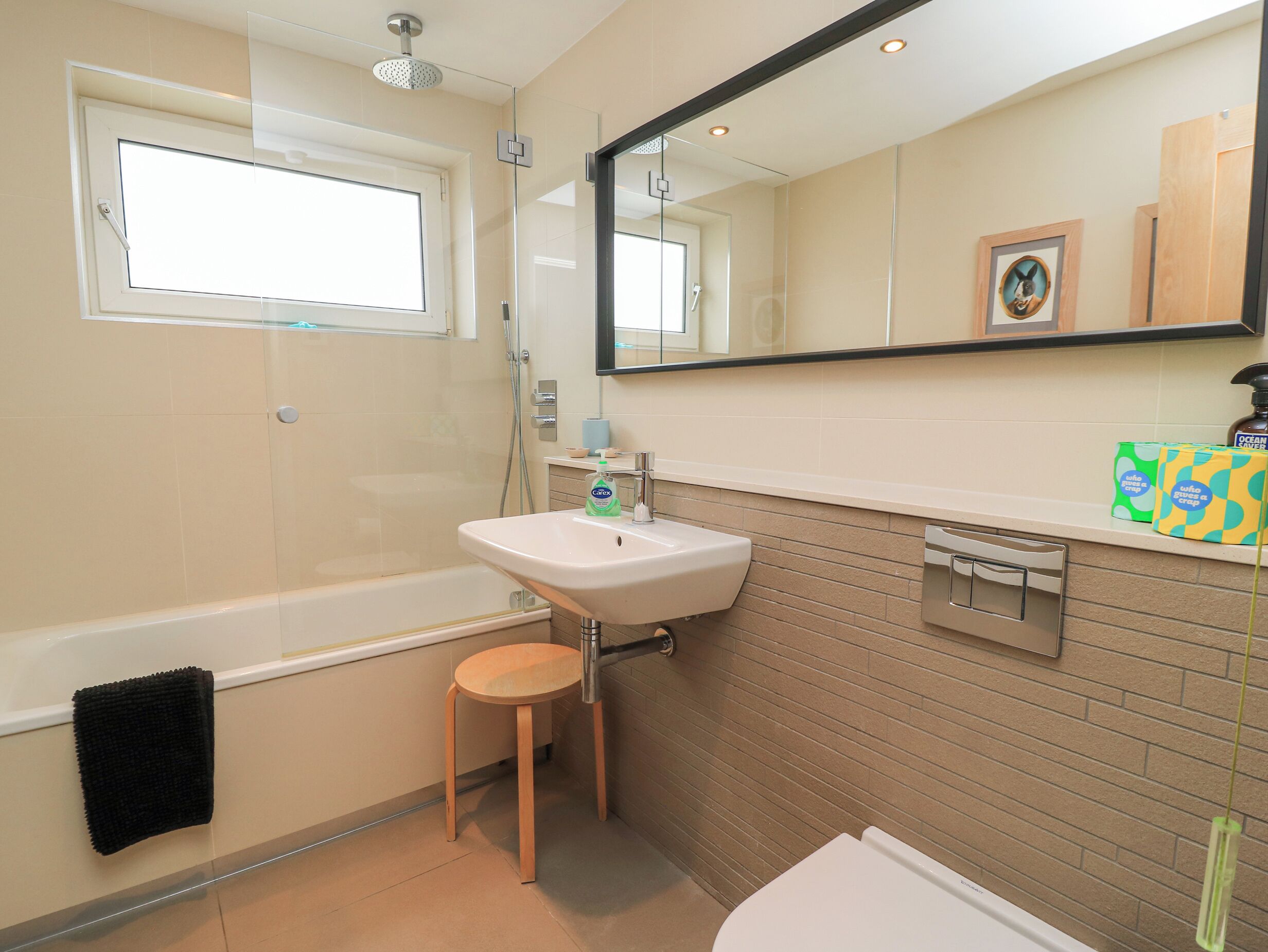 Un baño con bañera, lavabo, espejo y ventana.