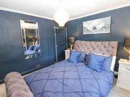 Un dormitorio con una cama grande, un espejo, un aparador y un cuadro colgado en la pared.