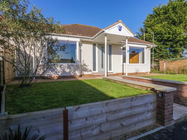 A modern house with a white exterior, a tiled roof, and a well-maintained lawn. - Farmer's Rest (Ely)