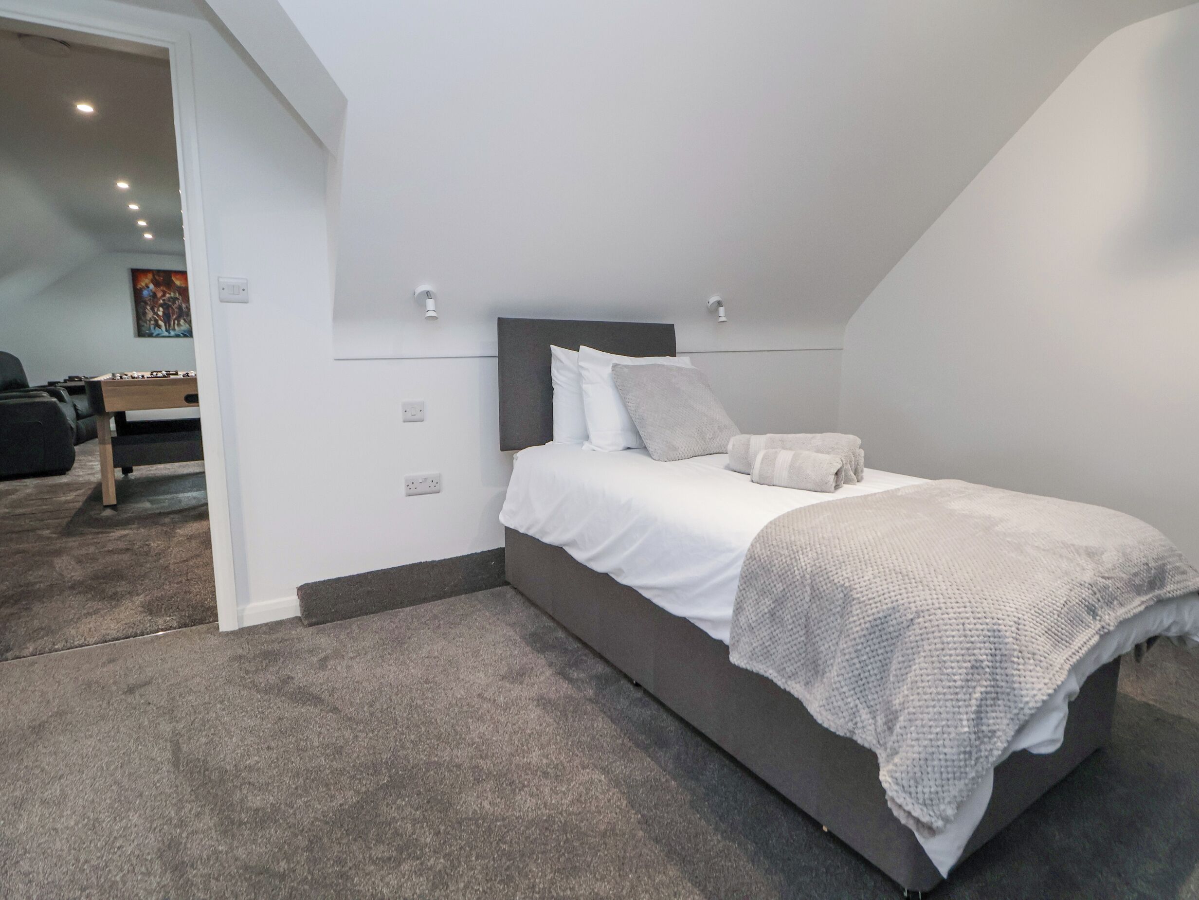 A bedroom with a bed, a headboard, and a carpeted floor.