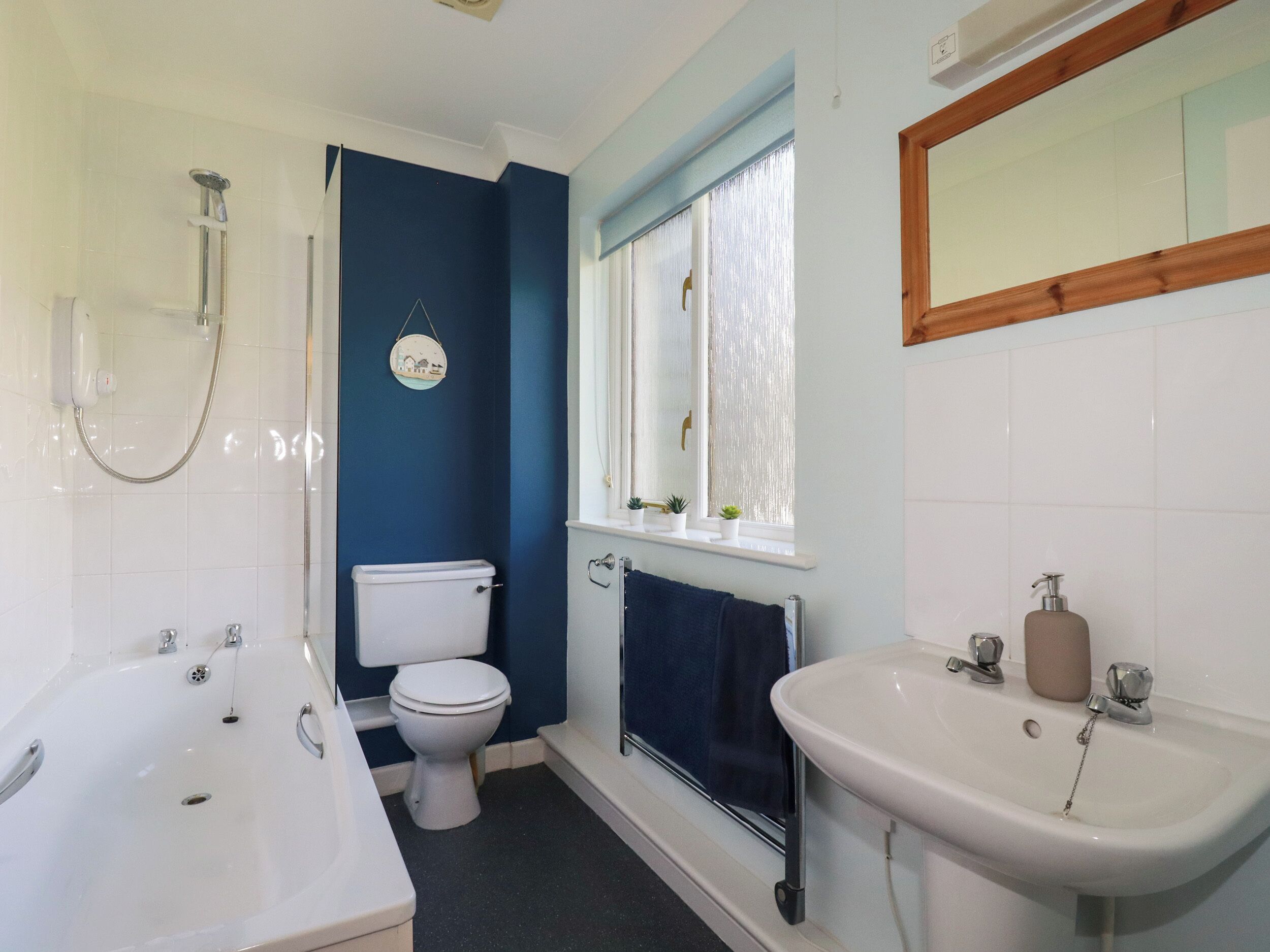 A bathroom with a bathtub, toilet, and sink.