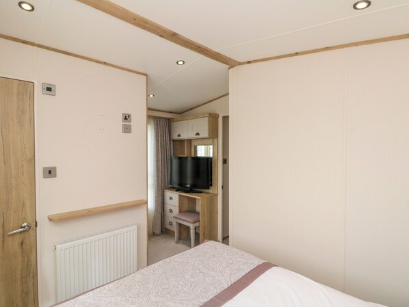 A bedroom with a bed, a wooden desk, a television, and a wardrobe. - Drake 11 (Scarborough)