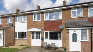 A two-story residential building with a front garden, a patio with a table and chairs, and a driveway. - 25 Resbury Close (Cambridge)