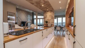 Una cocina moderna con encimera de madera, armarios blancos y un lavamanos empotrado.