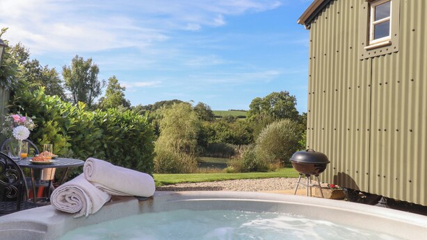 Un bain à remous avec vue sur un jardin et un bâtiment.