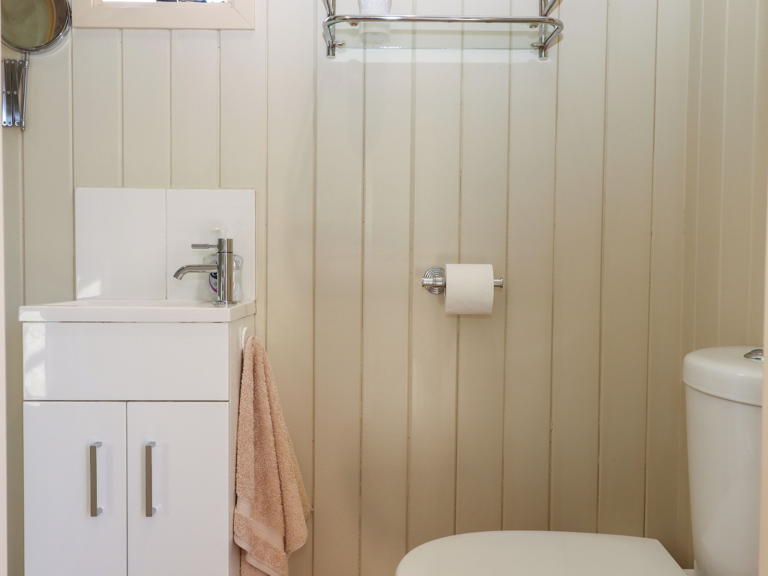 Un baño con inodoro, lavamanos y ducha.