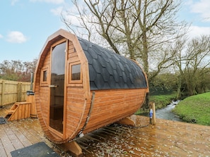A wooden cabin with a sloped roof, a door, and a window.