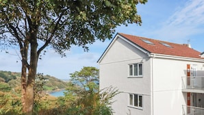 A two-story building with a red-tiled roof, white walls, and a balcony. - Godrevy View (St Ives)