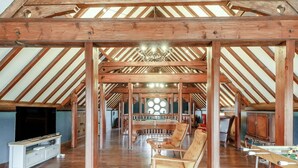 A spacious attic room with wooden beams, a pool table, and a billiards table. - The Old Chapel (Gainsborough)