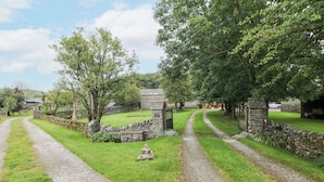 Un sentier rural mène à un bâtiment en pierre sur lequel est apposée une pancarte indiquant « Dam Field ».