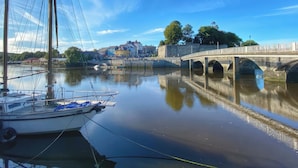 A river with a bridge and buildings in the background. - Rushfield (Cardigan)