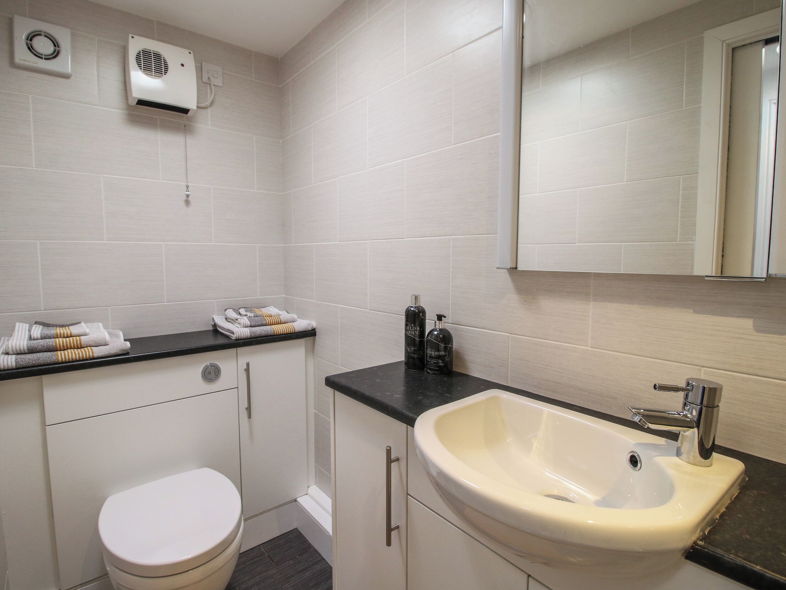 A modern bathroom with a toilet, sink, and towel rack.