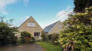 A stone house with a gravel driveway and a well-maintained garden. - Old Harry Cottage 16 (Swanage)