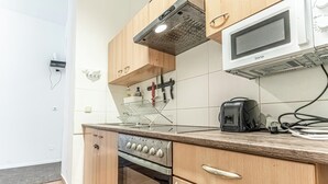 A kitchen with wooden cabinets, a built-in oven, a microwave, and a toaster. - 6BR Apt Lovely Garden Near Lorenz Böhler (Vienna)