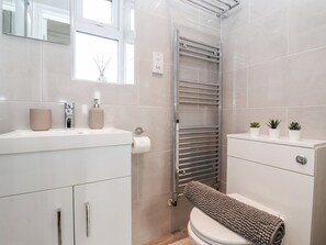 A modern bathroom with a toilet, sink, and towel rack.