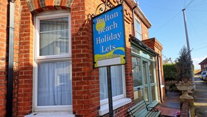Un edificio in mattoni con un cartello pubblicitario di 'Walton Beach Holiday Lets'.