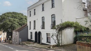 Un bâtiment blanc à deux étages, doté d’un toit plat, de nombreuses fenêtres et d’un petit balcon.