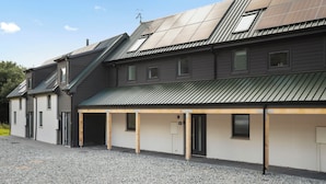 A building with a sloped roof, multiple windows, and a gravel driveway. - 26 Strathtay Lodges (Aberfeldy)
