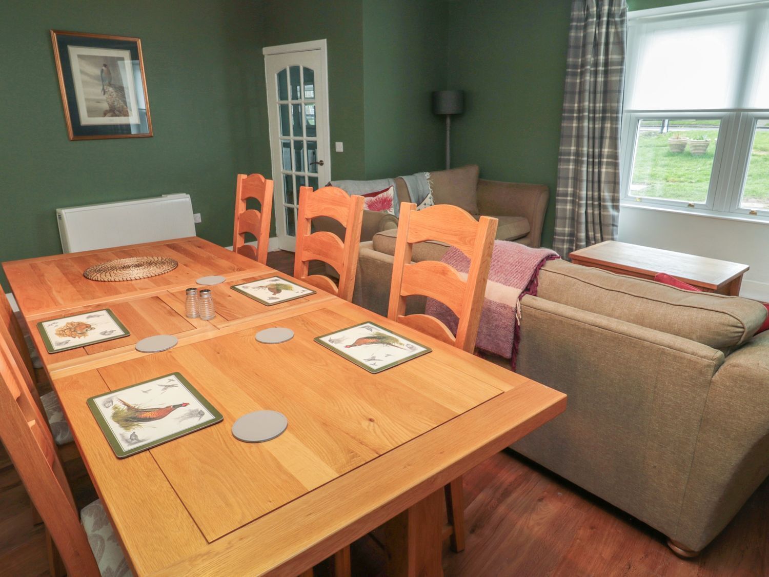 Un comedor con una mesa de madera, sillas y un sofá.