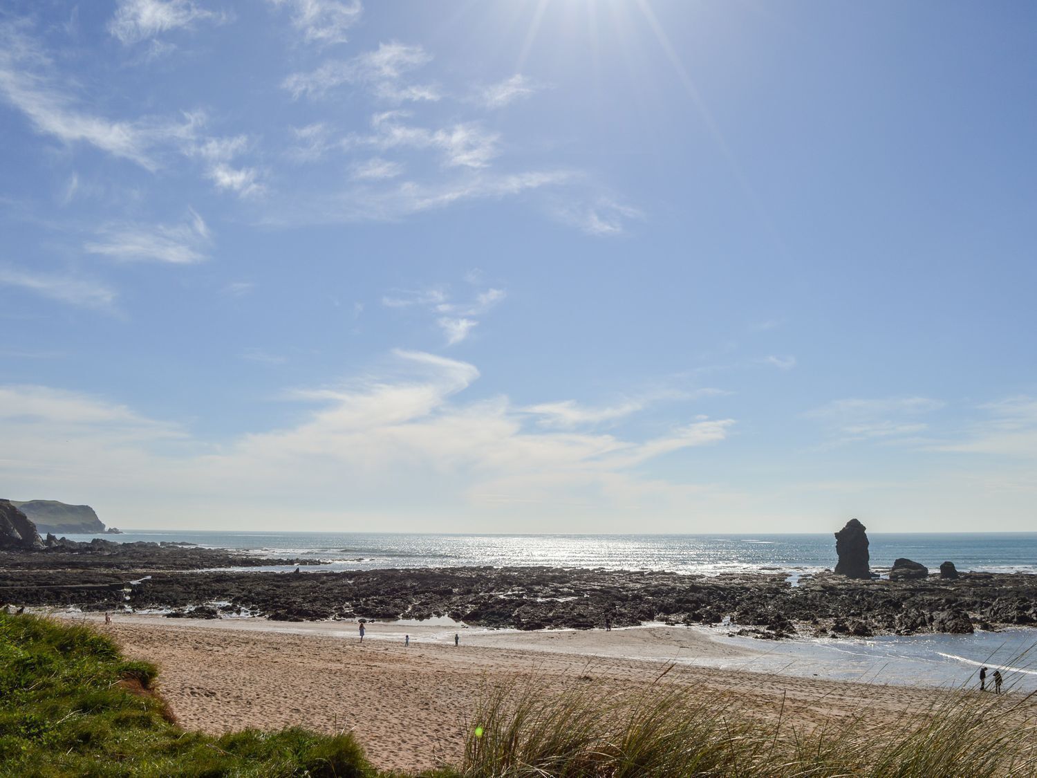 A beach with rocky terrain and a clear sky.