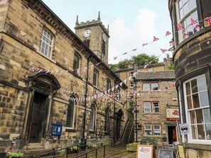 A historic stone building with a clock tower, a cafe, and a deli. - Valley View Cottage (Holmfirth)