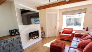 A living room with a fireplace, a sofa set, and a wooden floor. - Valley View Cottage (Holmfirth)