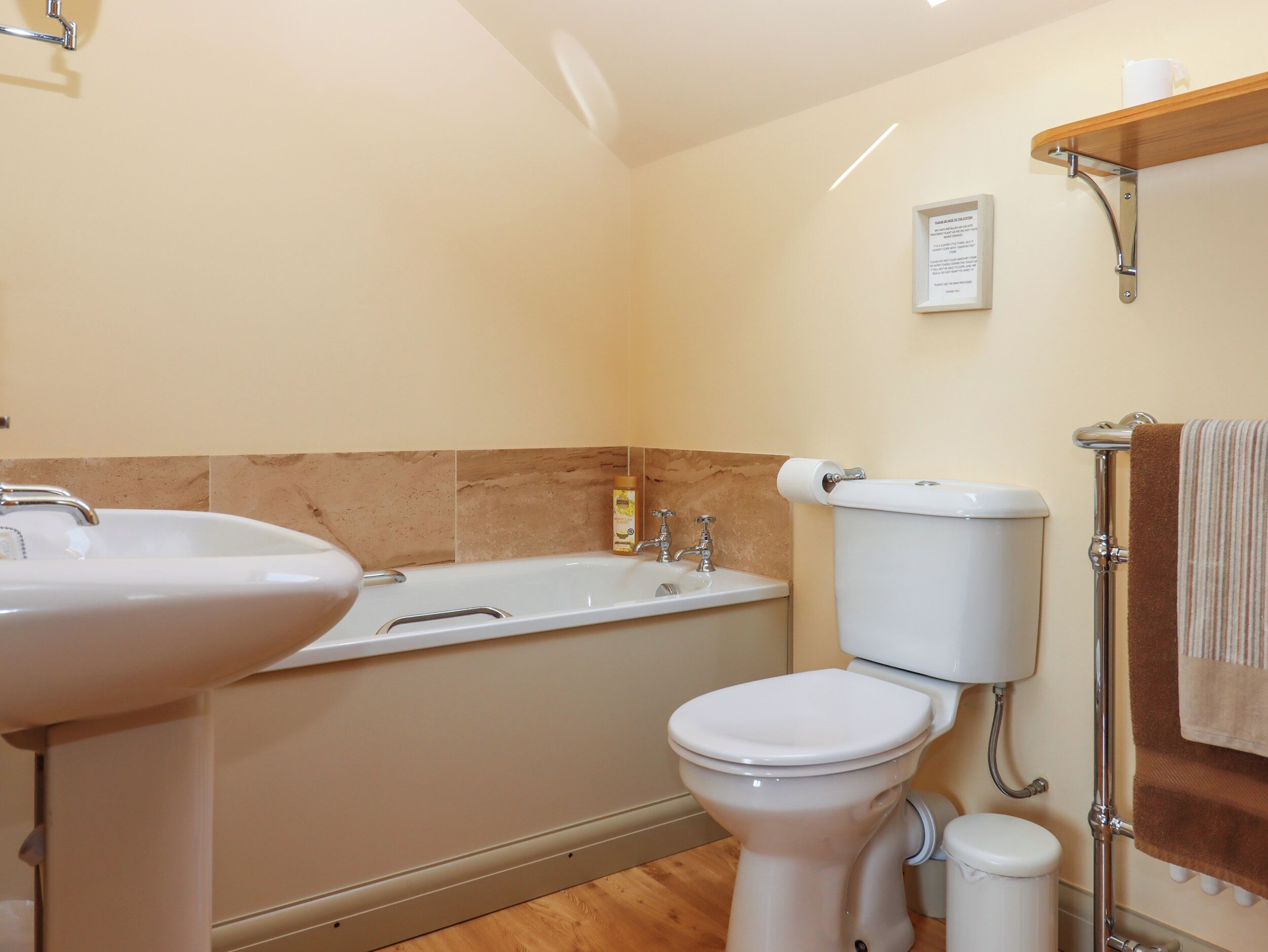 Ein Badezimmer mit Waschbecken, Badewanne, Toilette und Handtuchhalter.
