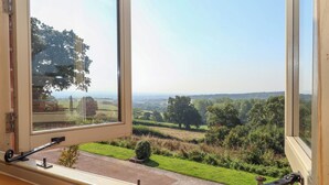 A window with a view of a rural landscape, including fields and trees. - Sherway Shippen (Exeter)