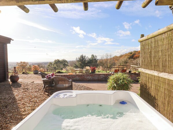 A hot tub with a view of a garden and hills. - Sherway Dairy (Exeter)