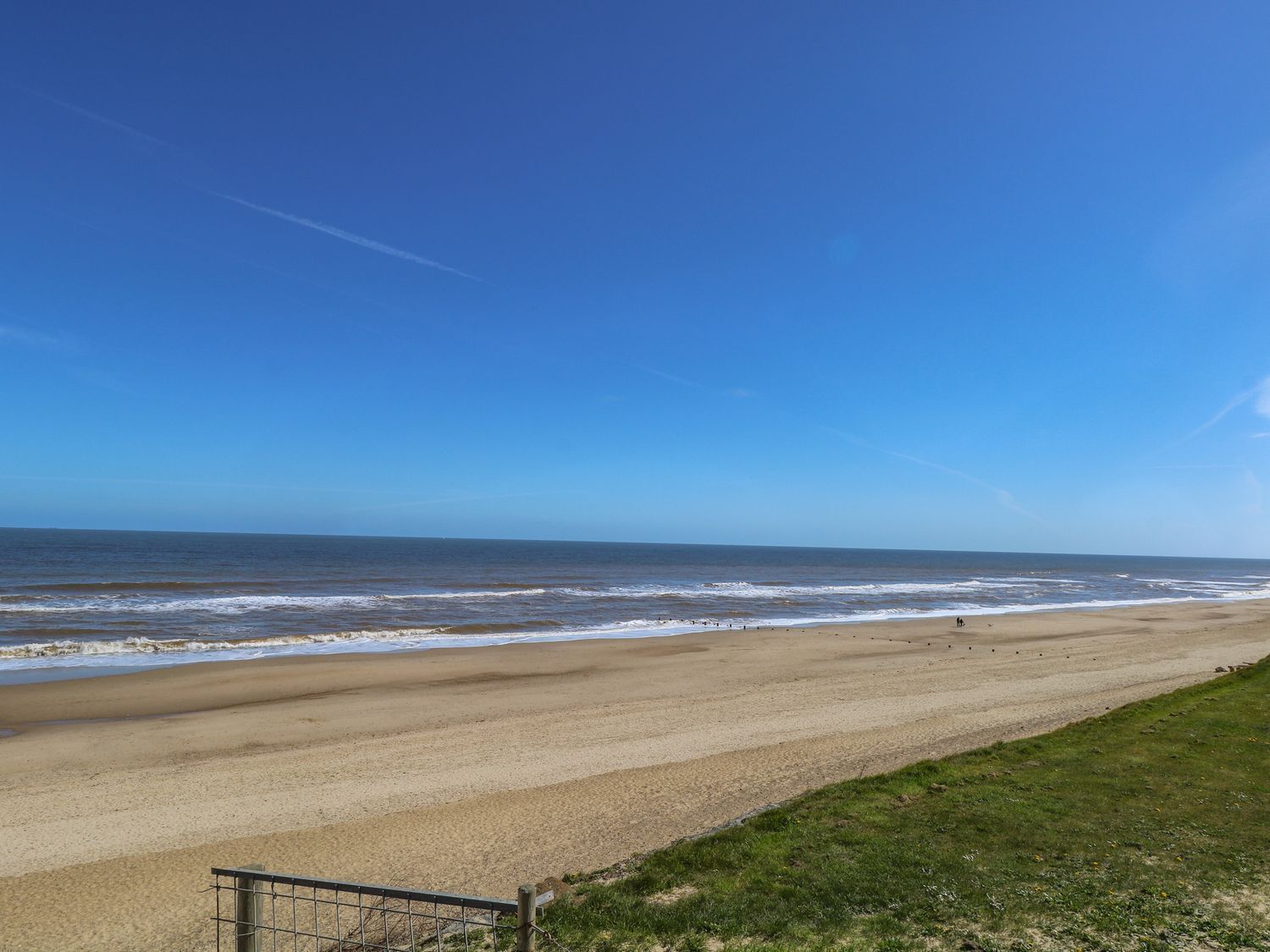 A beach with a clear sky and calm sea.
