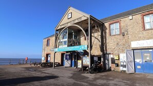 A building with a sign for 'Charming Heritage Coast Centre' and 'Free entry upstairs'. - 3 Grange Villas (Bridport)