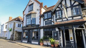 Un edificio tradicional con un letrero que dice 'The Puggle Coaching Inn', que presenta un pub y un bar.