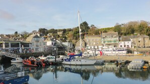 Un port où sont amarrés différents types de bateaux, notamment un voilier et un bateau à moteur.