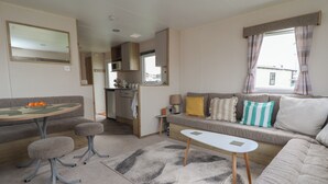 A compact living space with a dining area, kitchenette, and seating area. - Herrylock (Rhyl)
