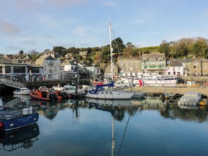 A harbor with boats docked, a bridge, and buildings in the background. - Kastel (Wadebridge)
