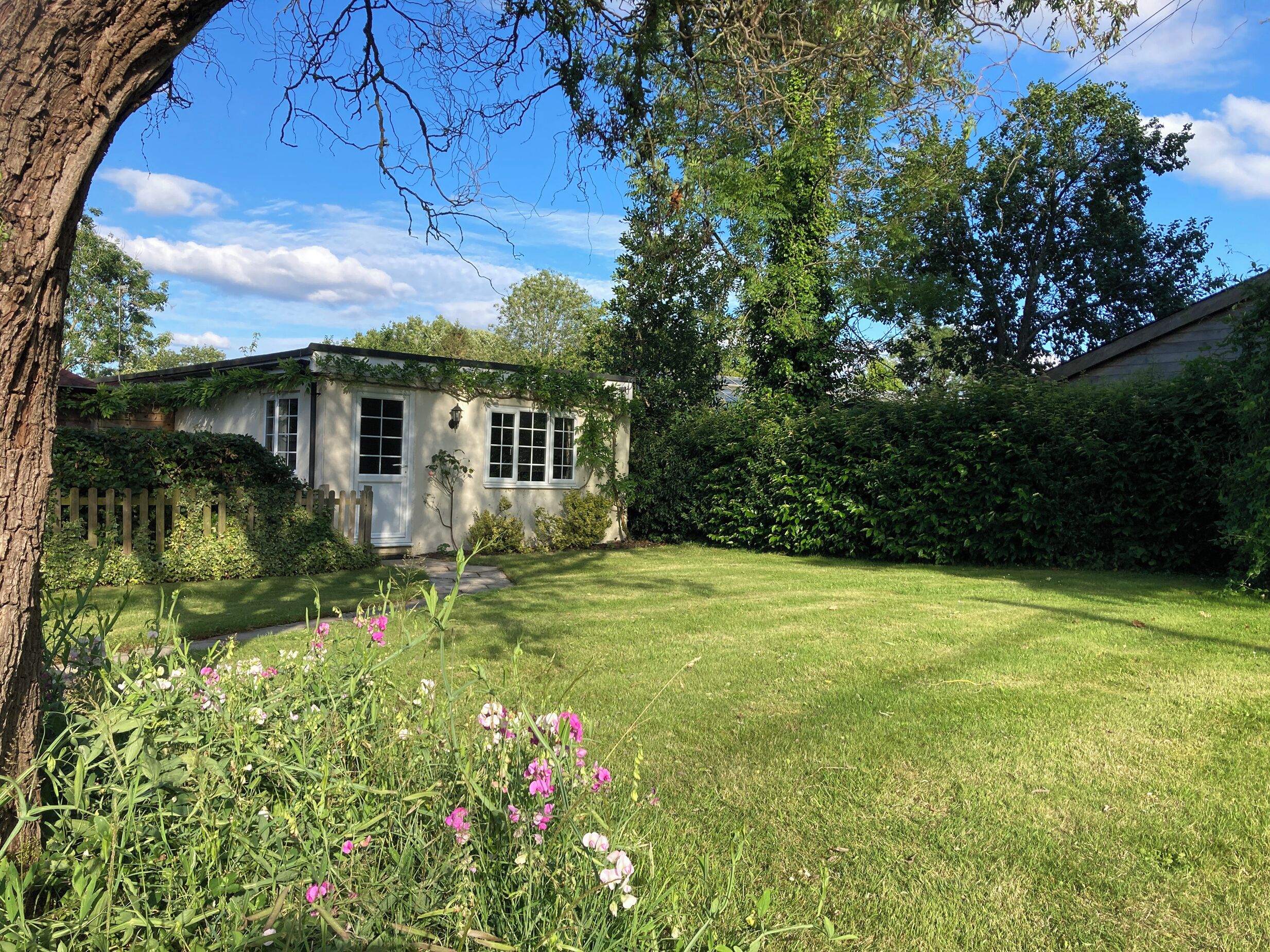 A house with a well-maintained lawn and a wooden fence.