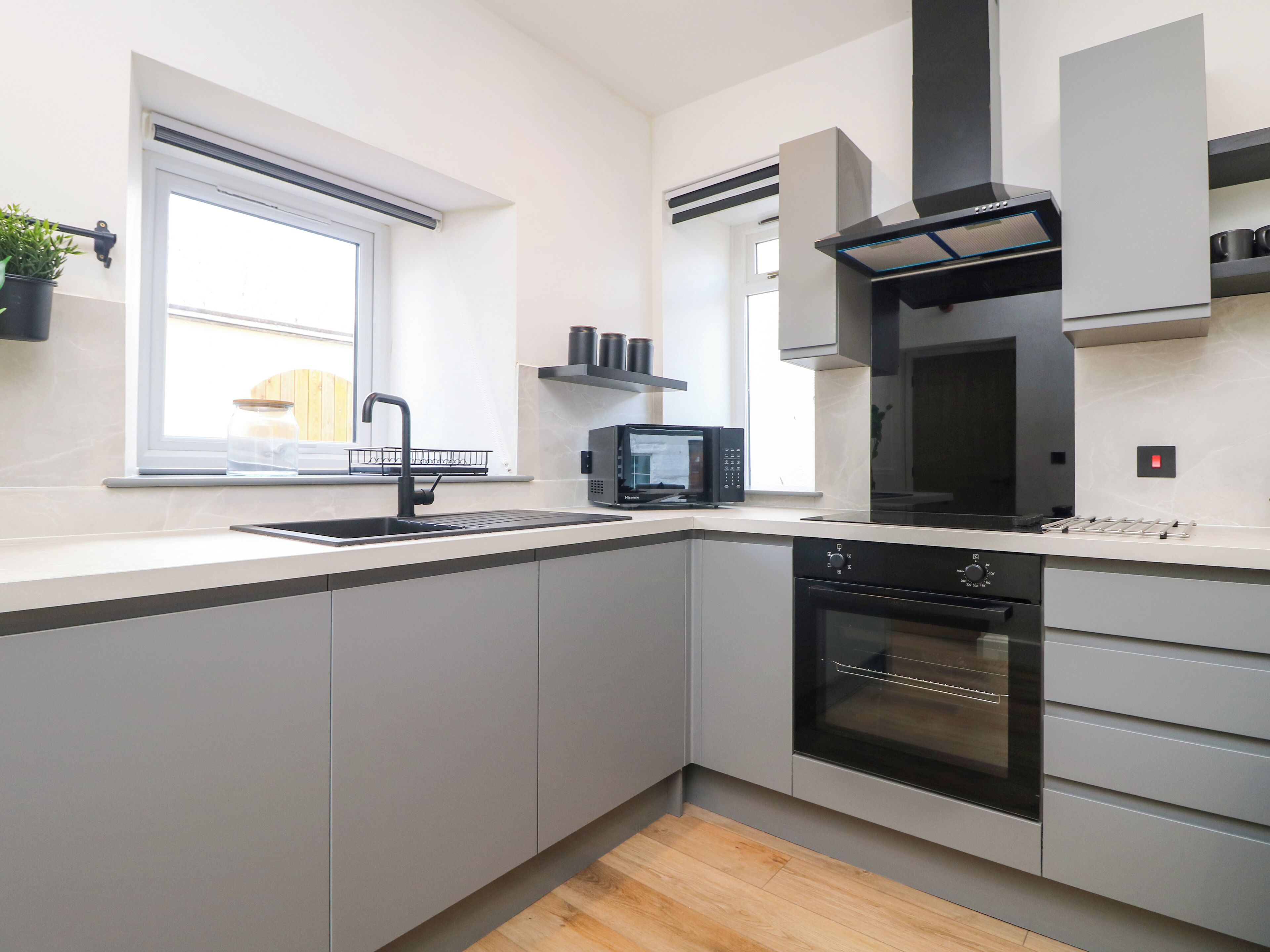 A modern kitchen with a built-in oven, microwave, and sink.