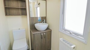 A bathroom with a toilet, a sink, a mirror, and a window. - 13 Gosling (Scarborough)