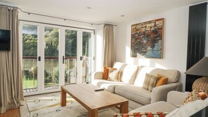 A spacious living room with a sofa set, a coffee table, and a painting on the wall.