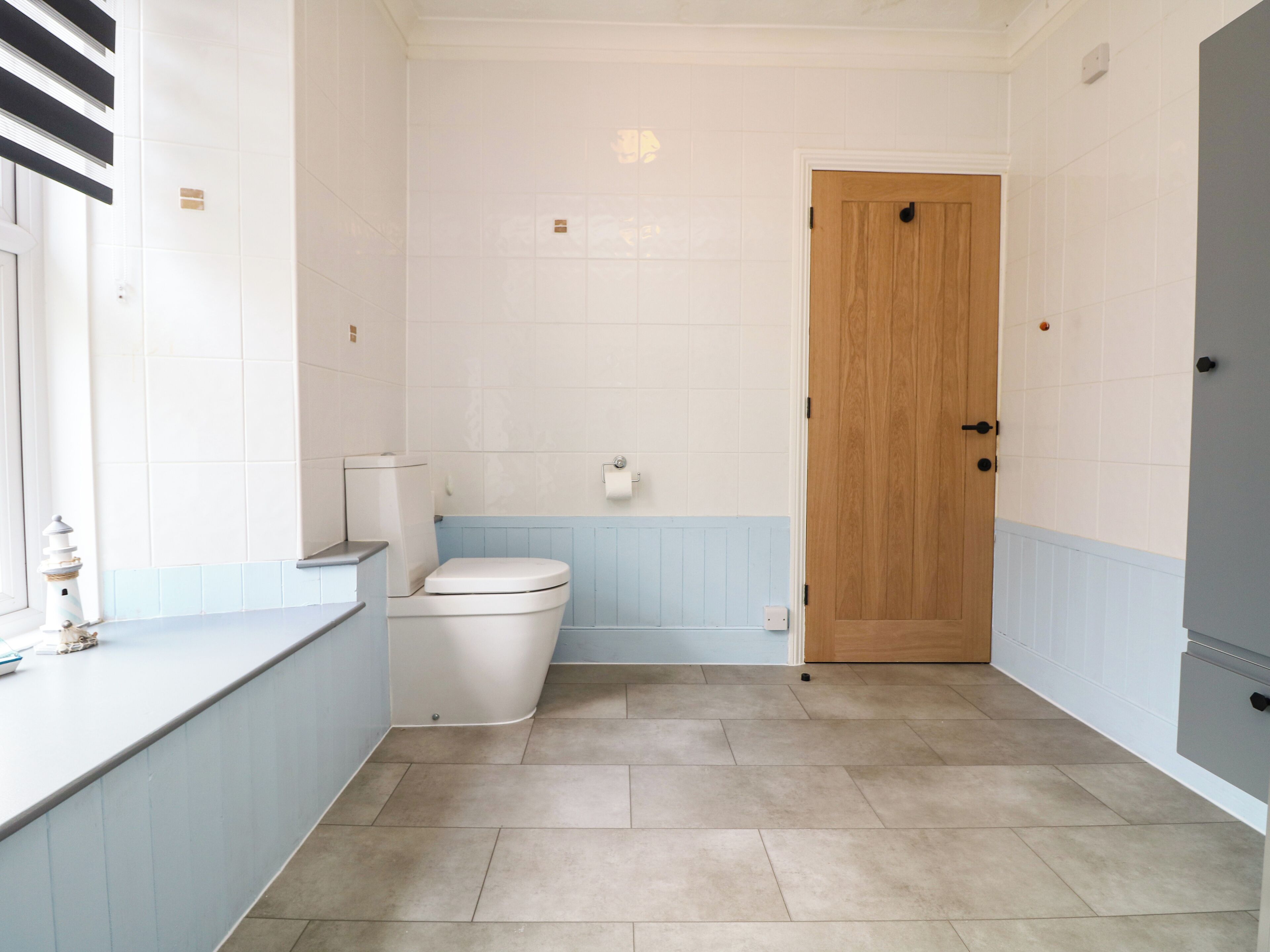 Une salle de bain avec des toilettes, un lavabo et une porte en bois.