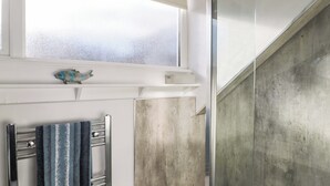 A bathroom with a towel rack, a decorative fish, and a frosted window. - Skyelands (Wooler)