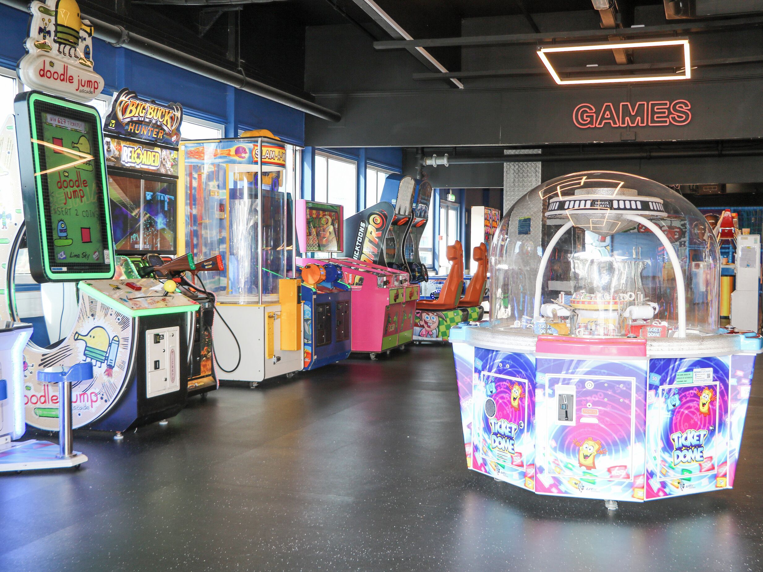 An arcade with various games, including 'Doodle Jump' and 'Big Buck Hunter'.