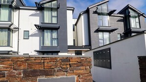 A modern residential building with a stone wall and a sign reading "SEASCAPE".