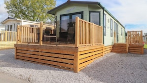 A small, single-story mobile home with a wooden deck and a covered porch. - Ashcroft (Preston)
