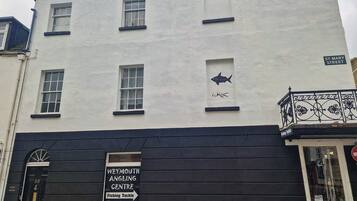 A building with a sign for Weymouth Angling Centre, a black door with the number 53, and a street sign for St. Mary Street.