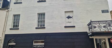 Un edificio con un cartel que indica Weymouth Angling Centre, una puerta negra con el número 53 y una señal de calle que dice St. Mary Street.