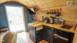 A compact kitchen with wooden cabinets, a black refrigerator, and a wooden countertop. - Hobhole (Spilsby)