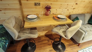 A wooden dining table with plates and cutlery, two chairs, a vase with flowers, and a wine glass. - Hobhole (Spilsby)