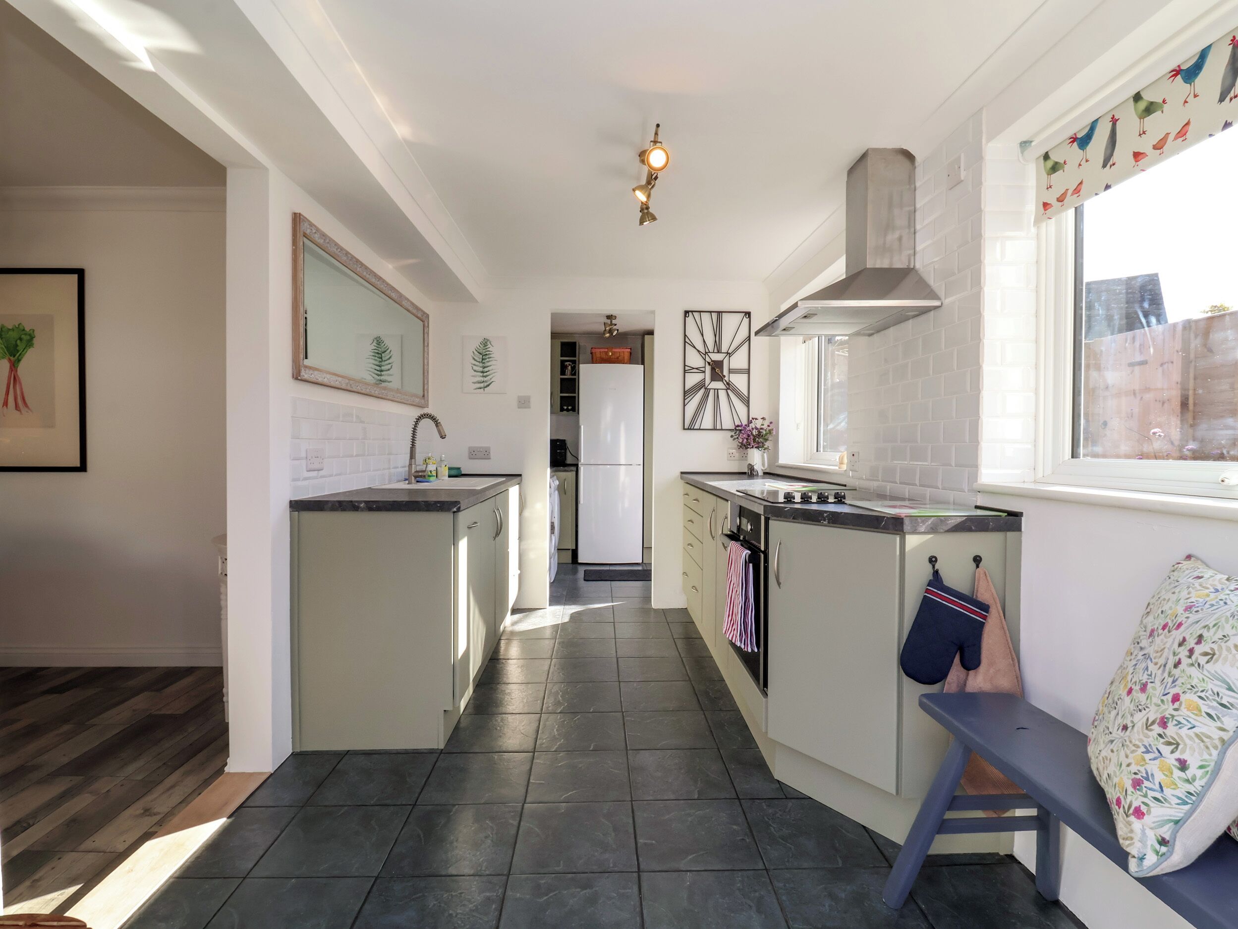 A modern kitchen with a central island, a built-in oven, and a window with a view.